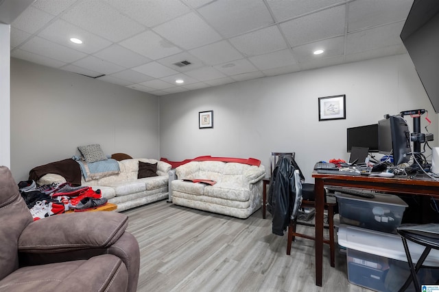 living room featuring a drop ceiling and light wood-type flooring