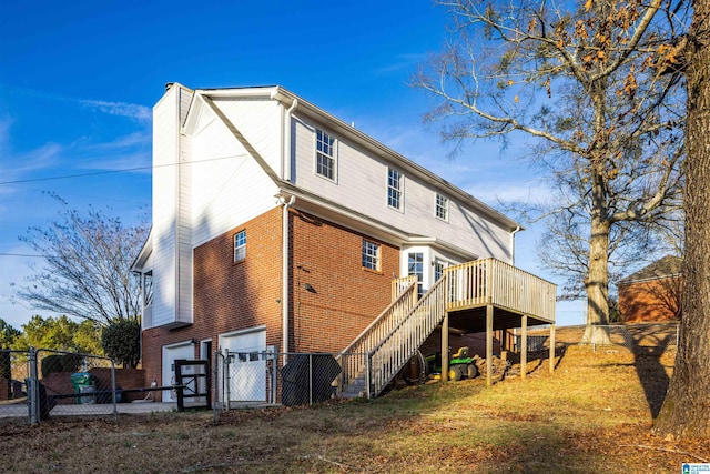 rear view of property with a garage and a wooden deck