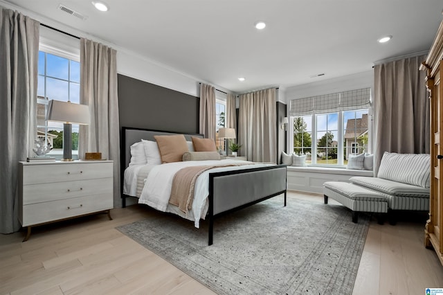 bedroom with light hardwood / wood-style flooring and crown molding