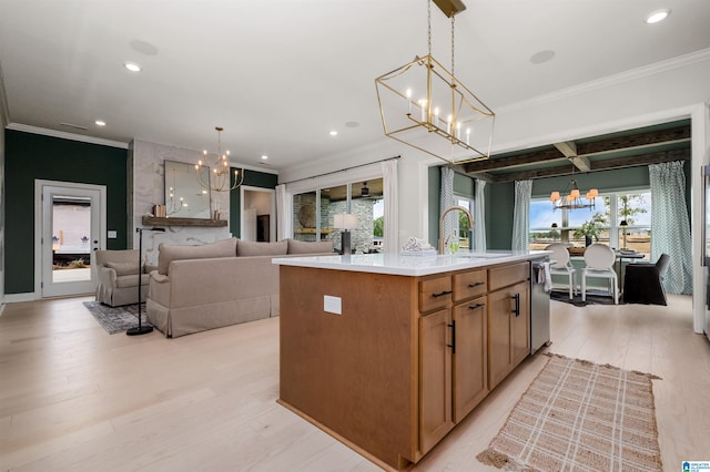 kitchen with light hardwood / wood-style flooring, a center island with sink, sink, and pendant lighting