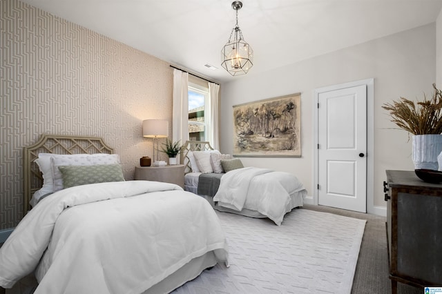 bedroom featuring light colored carpet and a chandelier