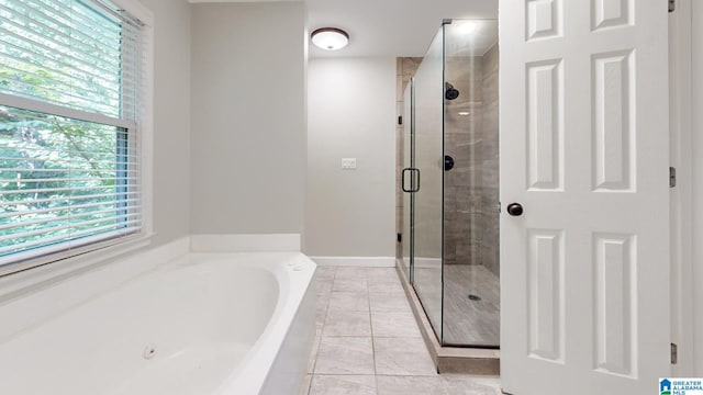 bathroom with a stall shower, plenty of natural light, a bath, and tile patterned floors