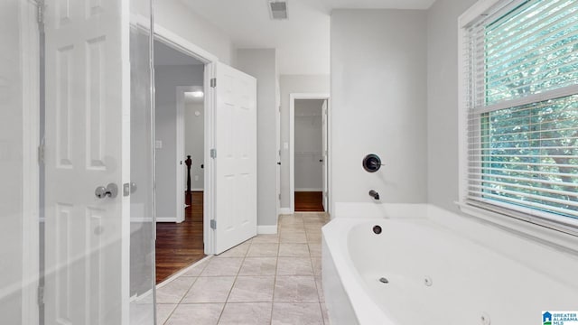 bathroom with a whirlpool tub, tile patterned flooring, and visible vents