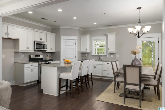 kitchen with tasteful backsplash, appliances with stainless steel finishes, and dark hardwood / wood-style flooring