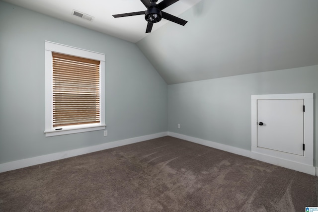 additional living space featuring dark carpet, vaulted ceiling, and ceiling fan