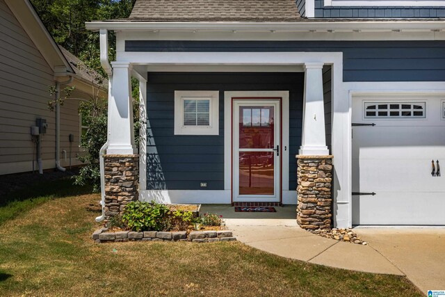 property entrance featuring a garage and a yard