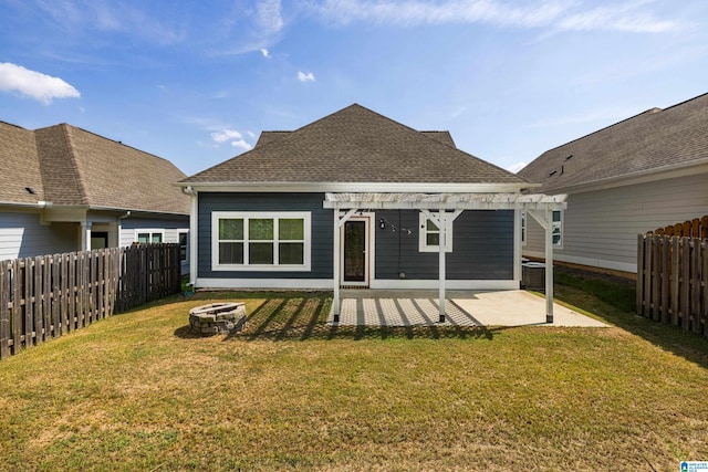 back of house with an outdoor fire pit, a yard, and a patio