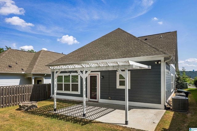 back of property with a pergola, central AC unit, a patio area, and a lawn