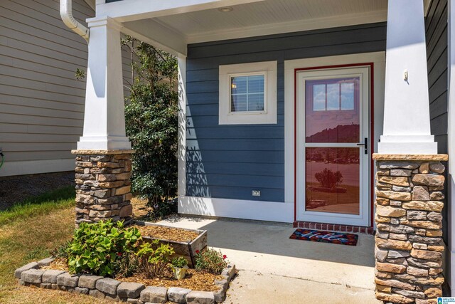 view of exterior entry featuring covered porch