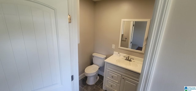 bathroom with toilet, vanity, and tile patterned flooring