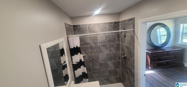 bathroom with wood finished floors, vanity, and a tile shower