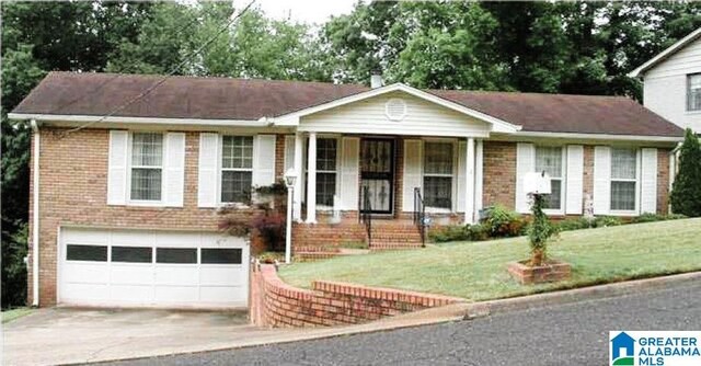 view of front of home with a front yard and a garage