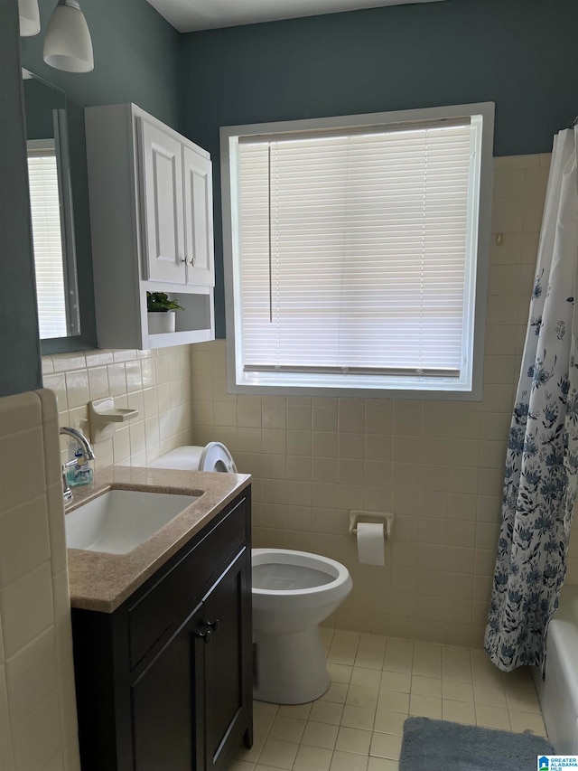 full bathroom with tile patterned flooring, toilet, shower / bathtub combination with curtain, tile walls, and vanity