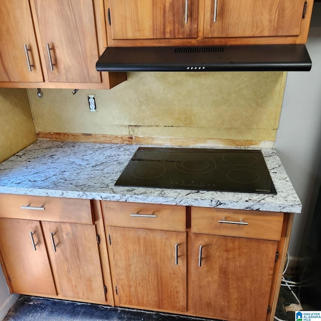 kitchen with light stone counters and black electric cooktop