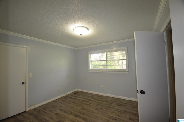 empty room with a textured ceiling, ornamental molding, and dark hardwood / wood-style flooring