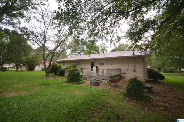 rear view of property with a yard and a deck