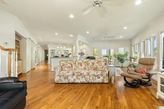 living room featuring ornate columns, crown molding, plenty of natural light, and light wood-type flooring