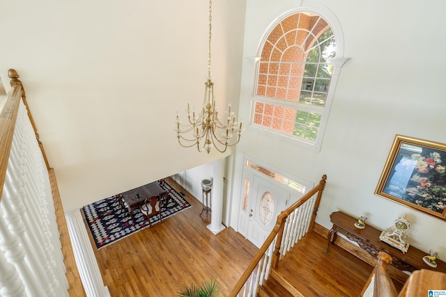 foyer with an inviting chandelier, hardwood / wood-style floors, and a high ceiling