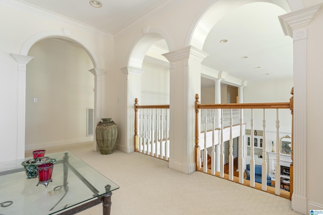 hallway with light colored carpet, ornamental molding, and decorative columns