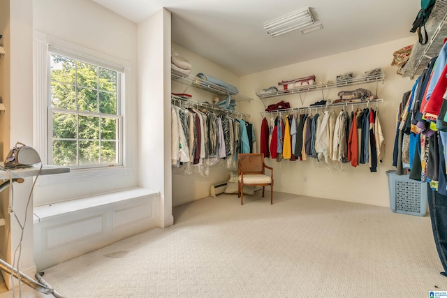 spacious closet with a baseboard heating unit and carpet flooring