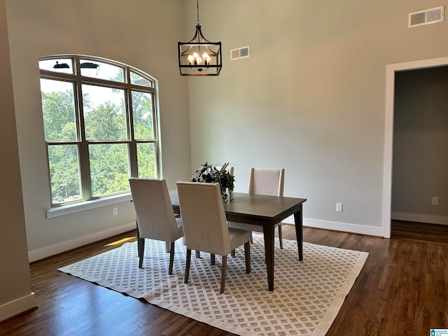 dining room featuring dark wood-type flooring and an inviting chandelier