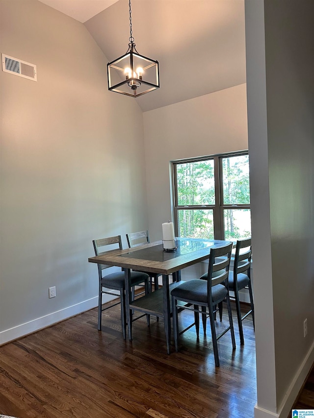 dining space featuring a notable chandelier, lofted ceiling, and dark wood-type flooring