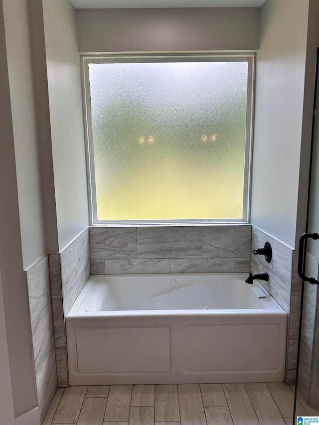 bathroom with a tub to relax in and a wealth of natural light