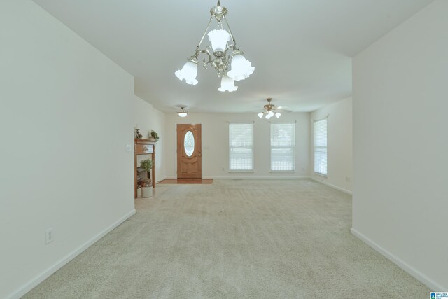 unfurnished living room featuring light colored carpet and ceiling fan with notable chandelier