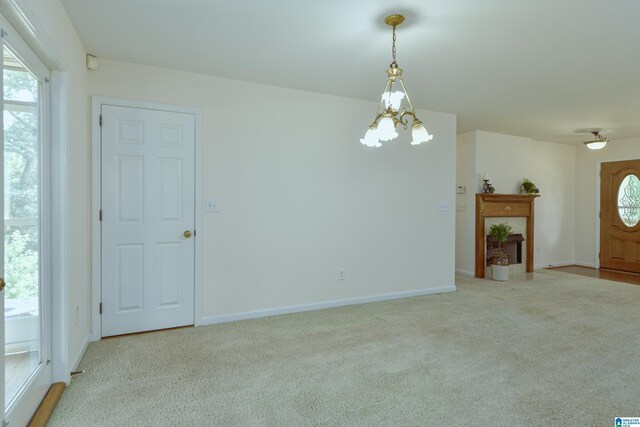 unfurnished living room with carpet floors and a notable chandelier