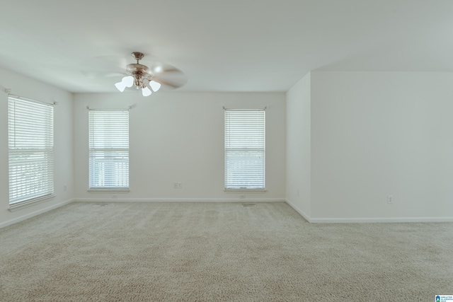 carpeted empty room featuring ceiling fan and a healthy amount of sunlight