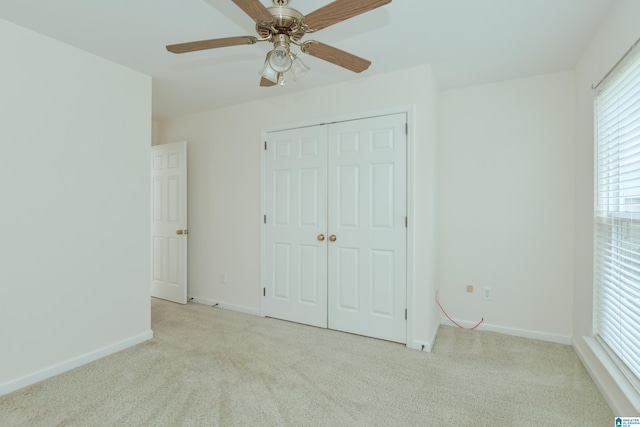 unfurnished bedroom featuring multiple windows, ceiling fan, and light colored carpet