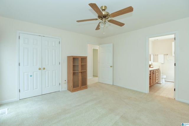 unfurnished bedroom featuring light carpet, a closet, and ceiling fan