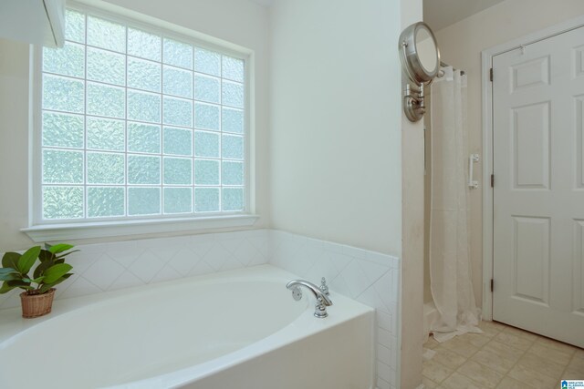 bathroom with a bath and tile patterned floors