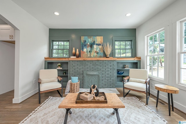 sitting room featuring hardwood / wood-style floors and a brick fireplace