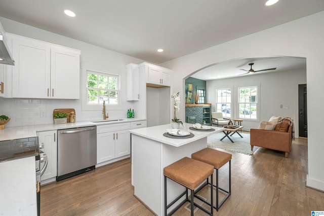 kitchen with electric stove, wood-type flooring, plenty of natural light, dishwasher, and sink