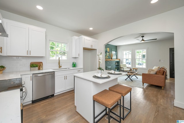 kitchen with sink, stainless steel appliances, tasteful backsplash, a healthy amount of sunlight, and white cabinets