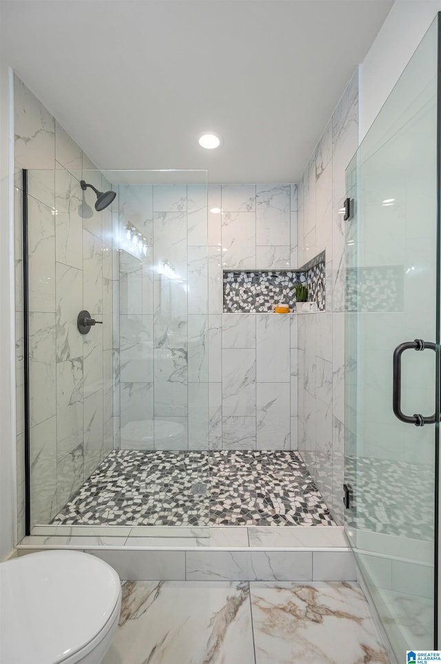 bathroom featuring tile patterned flooring, toilet, and a shower with shower door