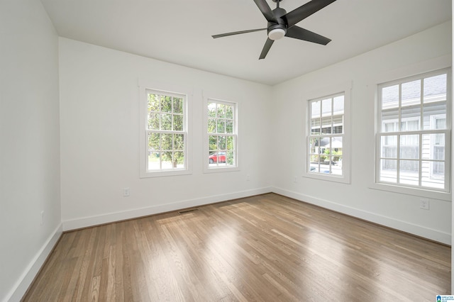 empty room featuring ceiling fan, light hardwood / wood-style flooring, and a healthy amount of sunlight