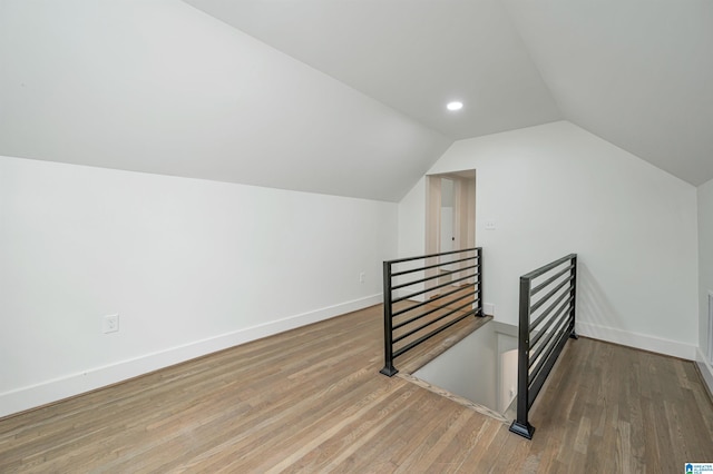 additional living space featuring wood-type flooring and vaulted ceiling