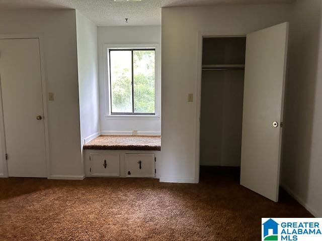 unfurnished bedroom featuring a textured ceiling and carpet flooring