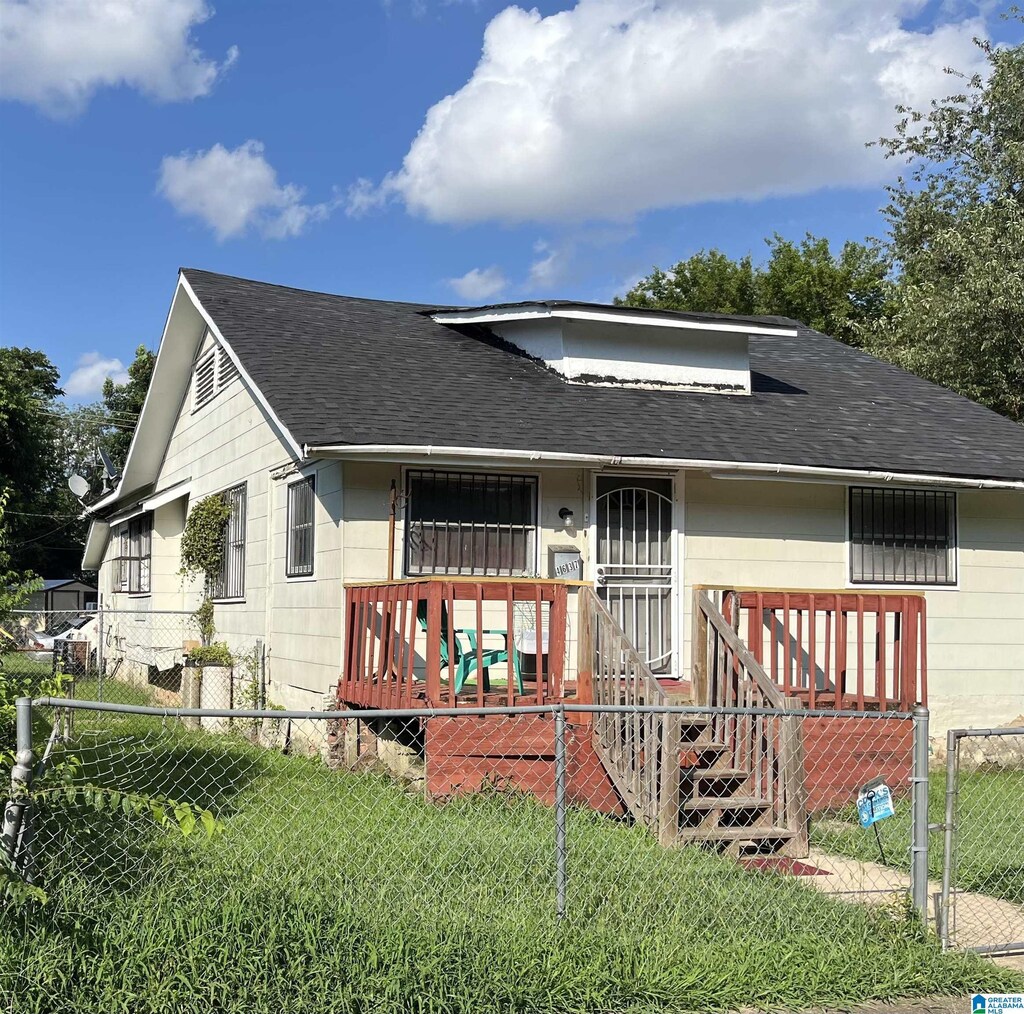 view of front facade with a shingled roof and a gate