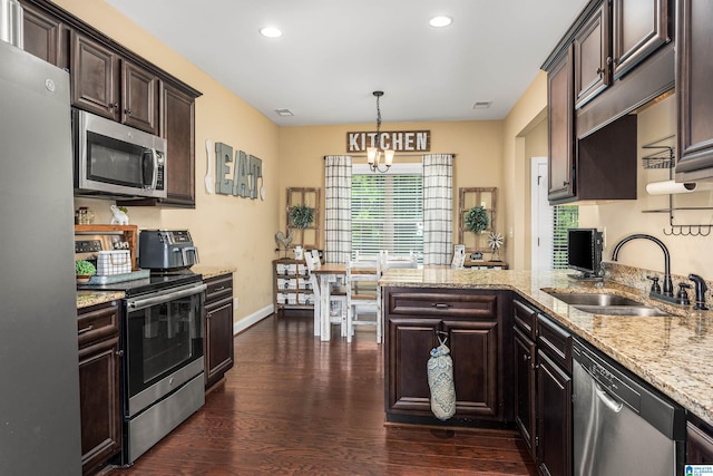 kitchen featuring a sink, dark wood-style floors, stainless steel appliances, a peninsula, and dark brown cabinets