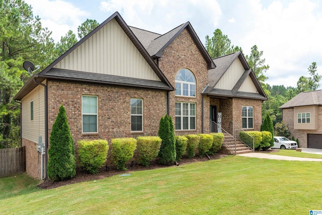 craftsman inspired home with fence, roof with shingles, brick siding, a front lawn, and board and batten siding