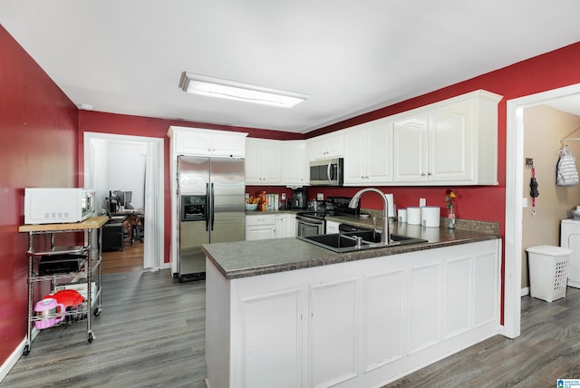 kitchen featuring kitchen peninsula, stainless steel appliances, hardwood / wood-style floors, and white cabinets