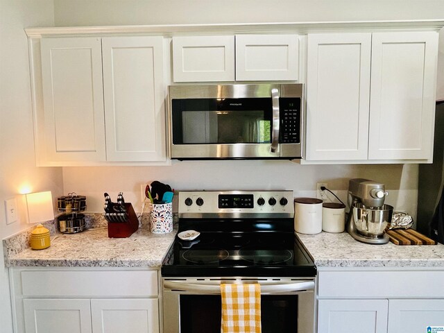 kitchen featuring white cabinetry, sink, hardwood / wood-style flooring, and appliances with stainless steel finishes