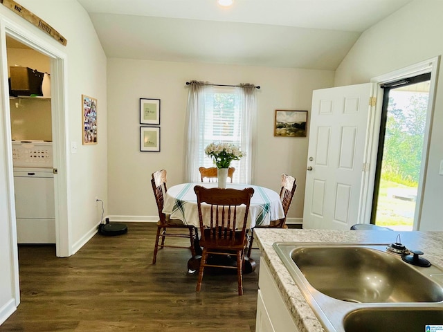 dining area featuring washer / clothes dryer, dark hardwood / wood-style flooring, vaulted ceiling, and sink