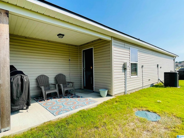 back of property featuring a lawn, central air condition unit, and a patio