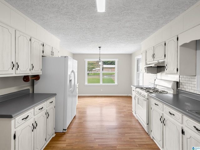 kitchen with white cabinets, light wood-type flooring, and white appliances