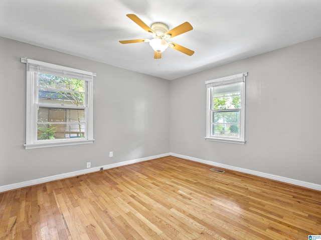 empty room featuring light hardwood / wood-style floors, a healthy amount of sunlight, and ceiling fan