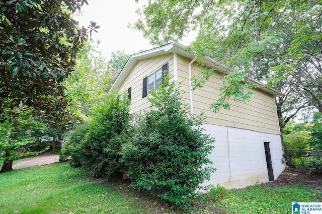 view of side of home with a yard